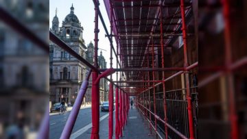 A path surrounded on all sides by scaffolding which is covered in red foam insulation