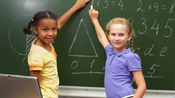 Two girls in front of chalkboard