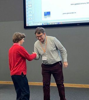 Clare receives the Lighthill–Thwaites prize from Alan Champneys