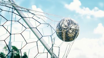 Football in motion in a goal net